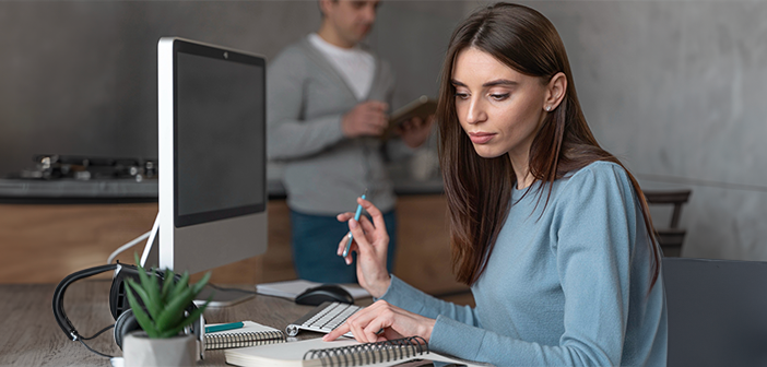 A focused female expert at a desk, working on a computer and taking notes. This image illustrates leveraging freelance experts to validate AI-driven systematic literature reviews